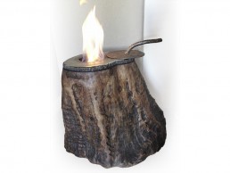 Redwood stump base with hollow in top face fitted with edge conforming steel top with fuel reservoir and handled lid.